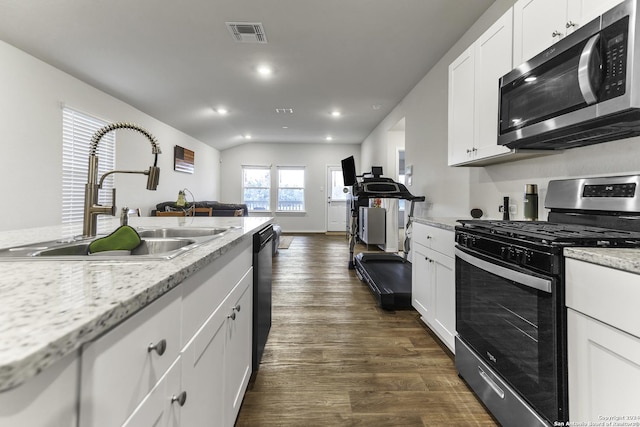 kitchen with light stone countertops, appliances with stainless steel finishes, sink, dark hardwood / wood-style floors, and white cabinetry