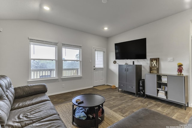 living room featuring dark hardwood / wood-style floors and vaulted ceiling