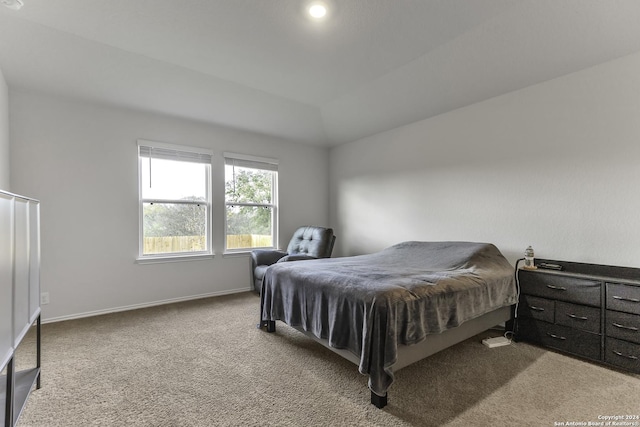 bedroom with light colored carpet and vaulted ceiling