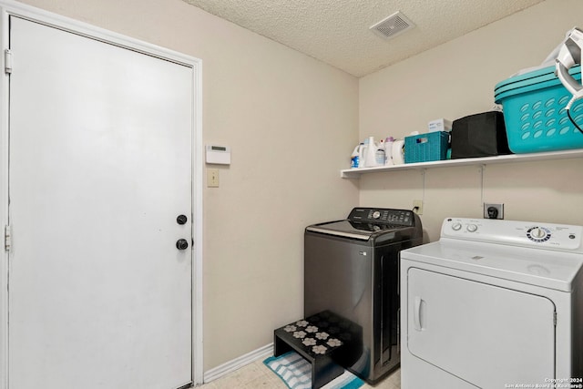 laundry area featuring washer and clothes dryer and a textured ceiling