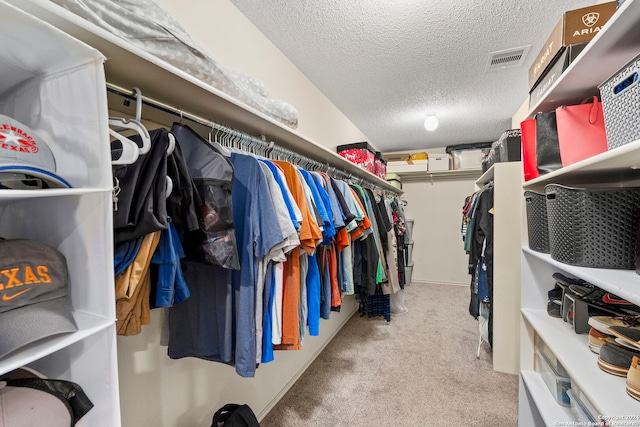 walk in closet featuring light carpet