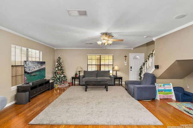 living room featuring crown molding, ceiling fan, and wood-type flooring