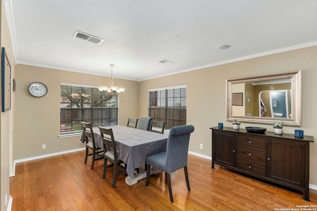 dining space featuring plenty of natural light, light hardwood / wood-style floors, ornamental molding, and an inviting chandelier