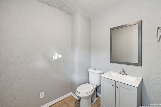 bathroom featuring tile patterned floors, vanity, toilet, and a textured ceiling