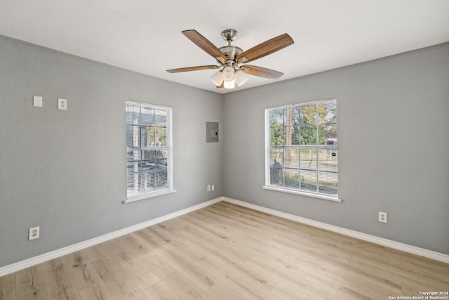 unfurnished room featuring electric panel, light hardwood / wood-style flooring, and ceiling fan