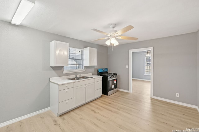 kitchen featuring white cabinets, stainless steel gas range oven, and light hardwood / wood-style flooring