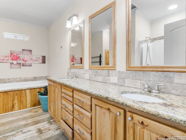 bathroom with tasteful backsplash, hardwood / wood-style floors, vanity, and ornamental molding