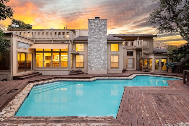 pool at dusk featuring a deck