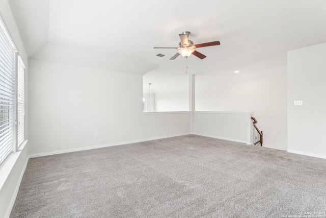 carpeted spare room with ceiling fan and vaulted ceiling