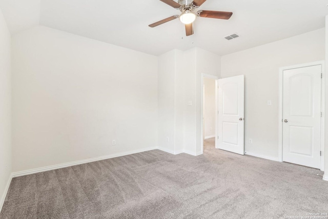 unfurnished bedroom featuring light carpet, vaulted ceiling, and ceiling fan