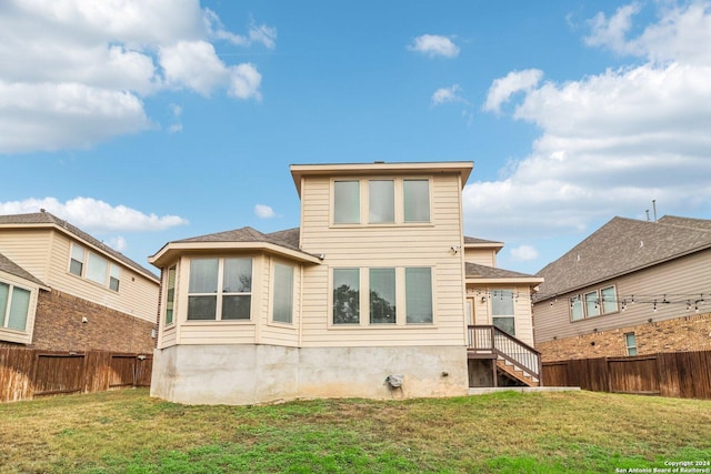 rear view of property featuring a lawn