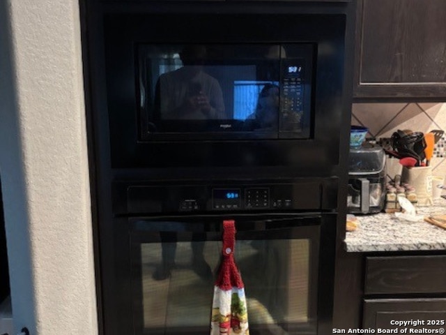 interior details featuring backsplash and black appliances