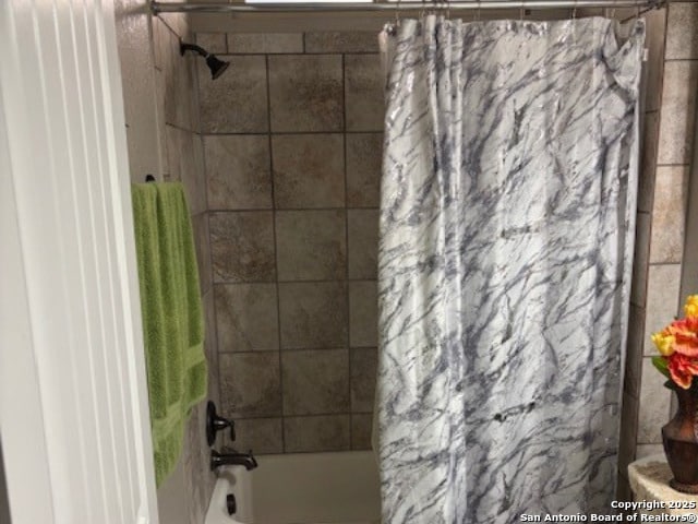 bathroom with toilet and shower / bath combo with shower curtain