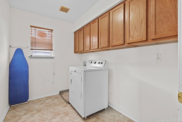 clothes washing area featuring cabinets and washer / clothes dryer