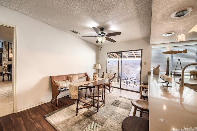 dining area with a textured ceiling, hardwood / wood-style flooring, and ceiling fan