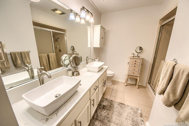 bathroom featuring toilet, vanity, tile patterned floors, and an enclosed shower