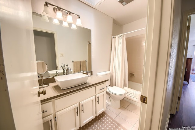 full bathroom with toilet, shower / bath combo with shower curtain, vanity, and tile patterned flooring