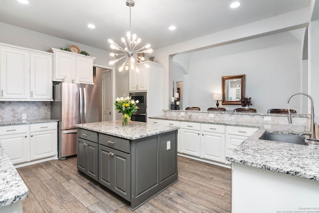 kitchen featuring gray cabinets, white cabinetry, sink, and appliances with stainless steel finishes