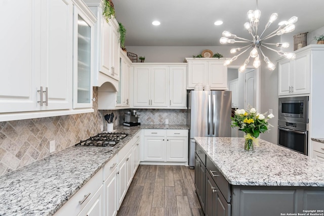 kitchen with dark wood-type flooring, gray cabinets, appliances with stainless steel finishes, a notable chandelier, and white cabinetry