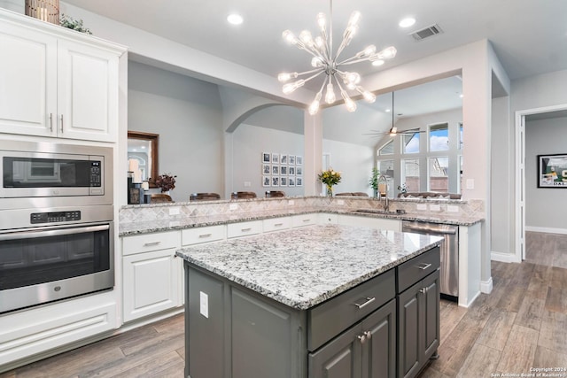 kitchen with gray cabinets, a kitchen island, white cabinets, and appliances with stainless steel finishes