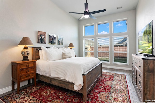 bedroom featuring ceiling fan, high vaulted ceiling, and light wood-type flooring