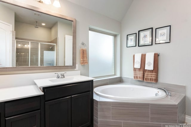 bathroom with plus walk in shower, vanity, and vaulted ceiling