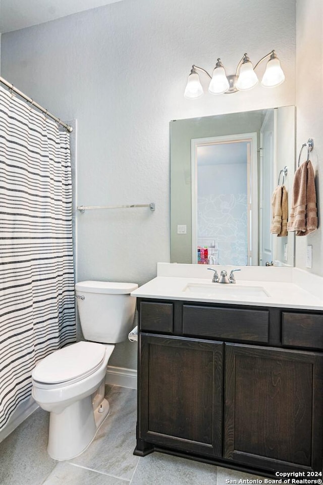 bathroom with tile patterned flooring, vanity, and toilet