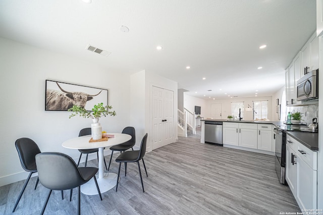 7427 Vega Gap, San Antonio, TX 78252 - dining room with light wood-style floors, recessed lighting, and stairway