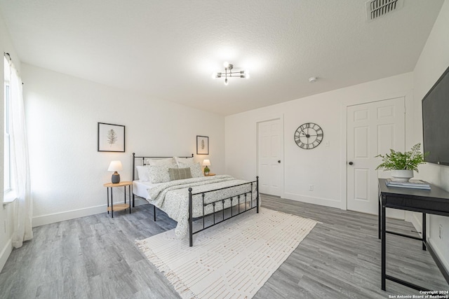 bedroom featuring hardwood / wood-style floors and a textured ceiling