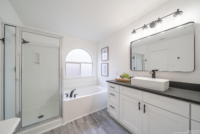 bathroom with plus walk in shower, wood-type flooring, and vanity