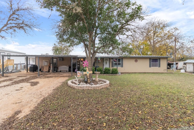 back of house with a carport and a lawn