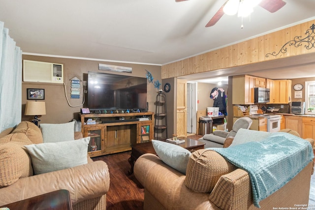 living room with a wall unit AC, ceiling fan, dark wood-type flooring, and ornamental molding