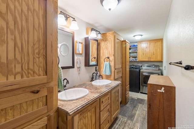 bathroom with vanity, hardwood / wood-style flooring, and washing machine and clothes dryer