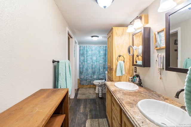 bathroom featuring a shower with shower curtain, hardwood / wood-style floors, vanity, and toilet