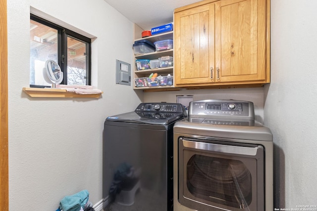 laundry area with washer and clothes dryer and cabinets