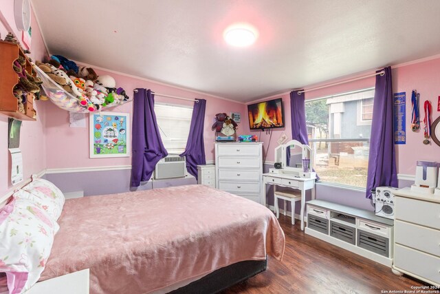 bedroom with cooling unit and dark hardwood / wood-style flooring