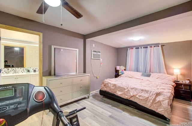 bedroom featuring ceiling fan, a wall mounted air conditioner, and light wood-type flooring