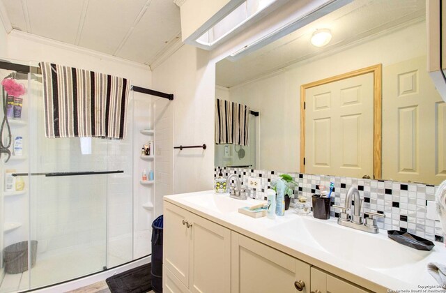 bathroom with decorative backsplash, vanity, an enclosed shower, and ornamental molding