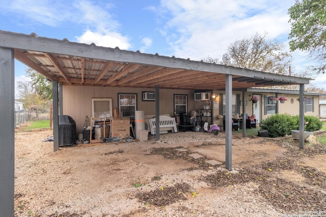 rear view of house featuring a carport and a wall mounted air conditioner