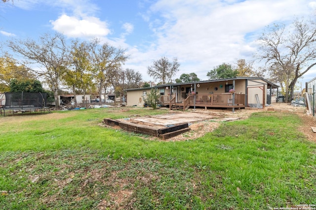 view of yard with a deck and a trampoline