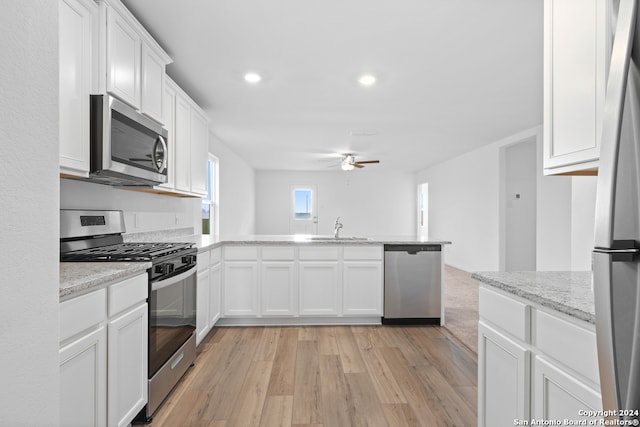 kitchen with white cabinetry, sink, appliances with stainless steel finishes, and light hardwood / wood-style flooring