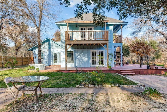 back of house featuring a balcony and a wooden deck