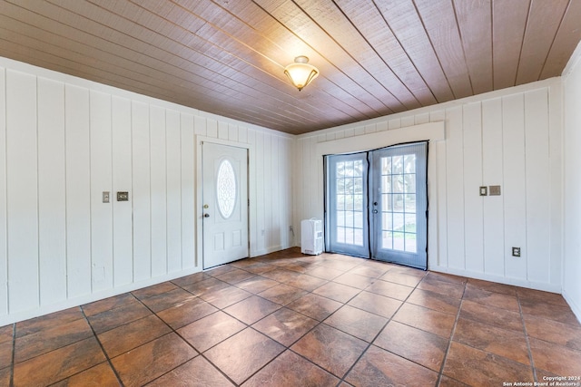 foyer featuring french doors, wooden walls, and wooden ceiling