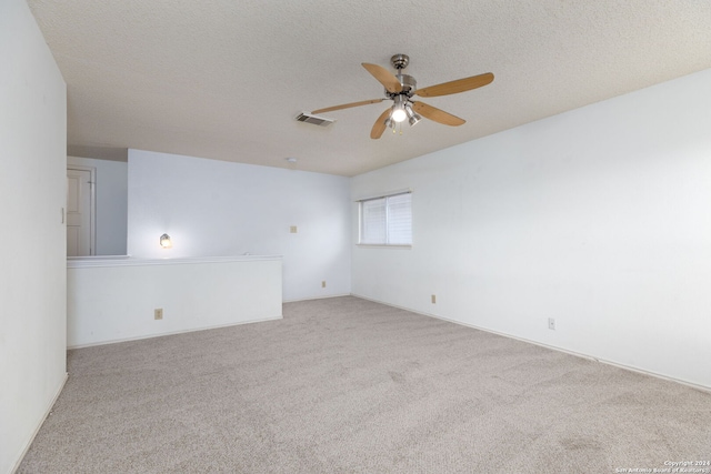 carpeted empty room featuring ceiling fan and a textured ceiling