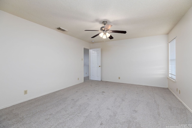 unfurnished room with ceiling fan, light colored carpet, and a textured ceiling