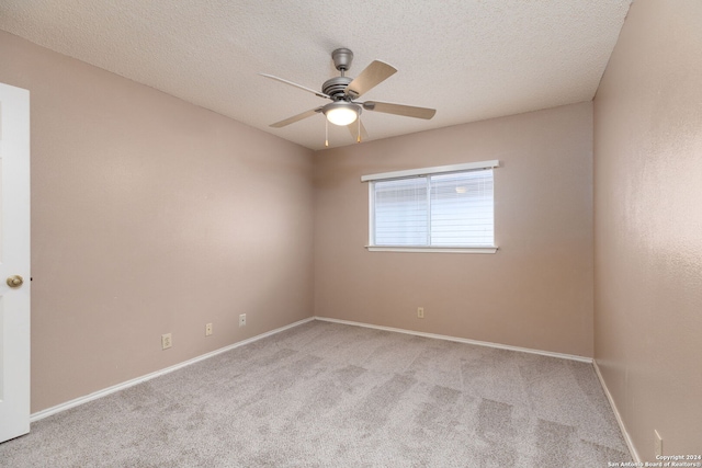 carpeted empty room with a textured ceiling and ceiling fan