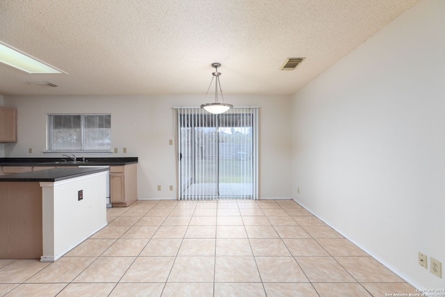 kitchen featuring pendant lighting, a textured ceiling, and light tile patterned floors