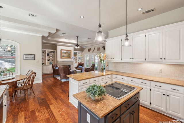 kitchen with white cabinetry, a kitchen island, black electric stovetop, and decorative light fixtures