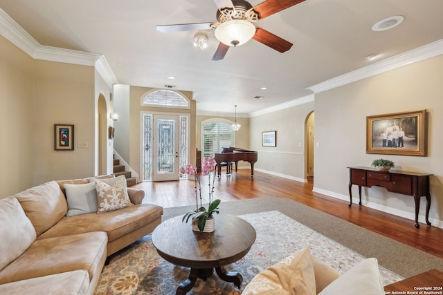 living room featuring hardwood / wood-style floors, ornamental molding, and ceiling fan