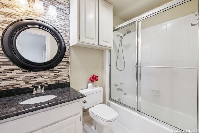 full bathroom with vanity, decorative backsplash, combined bath / shower with glass door, and toilet